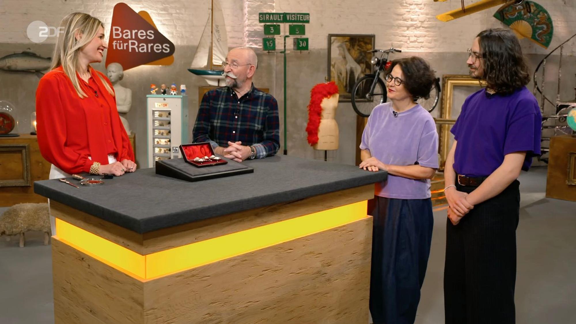 Verkäuferin Verena war mit Sohn Julian (rechts) zu „Bares für Rares“ angereist. Expertin Bianca Berding (links) und Moderator Horst Lichter konnten sich für ihr Objekt begeistern. (Bild: ZDF)
