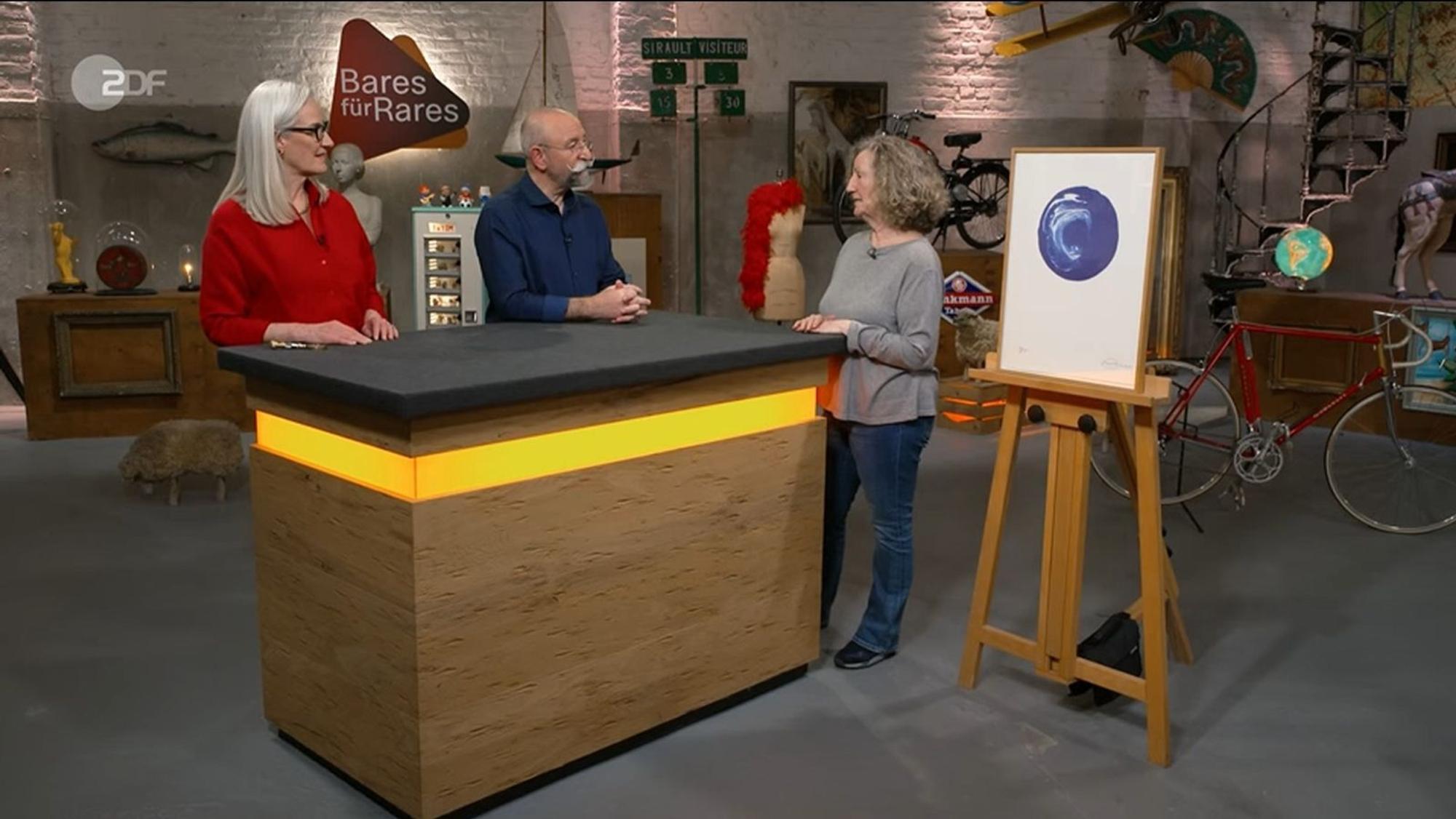 „Alles hat seine Zeit“, fand Pia: Das Geschenk ihrer ehemaligen Chefin passte farblich nicht mehr in ihre neue Wohnung und sollte deshalb weiterziehen. Otto Pienes schlicht gerahmter „Blauer Planet“ von 2003 war bestens erhalten und wurde auf 400 bis 600 Euro geschätzt. (Bild: ZDF)