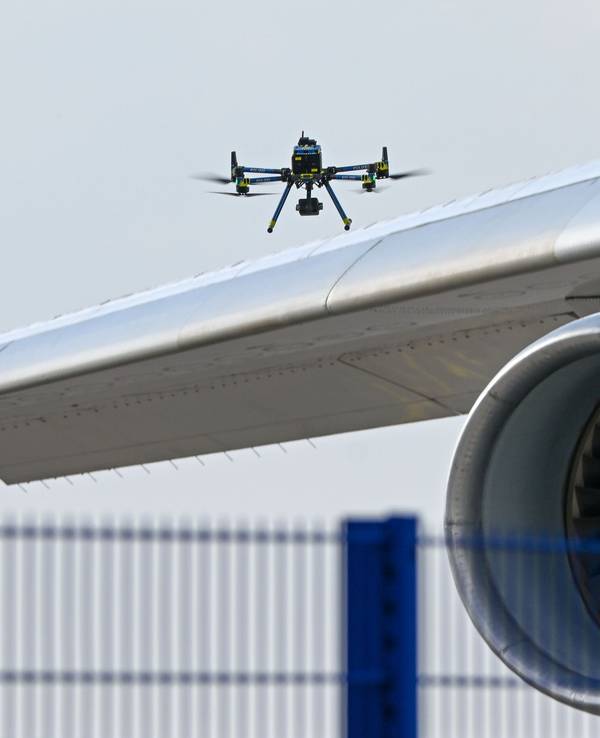 Eine Drohne der Polizei ist über einer Flugzeugtragfläche zu sehen. (Symbolfoto)