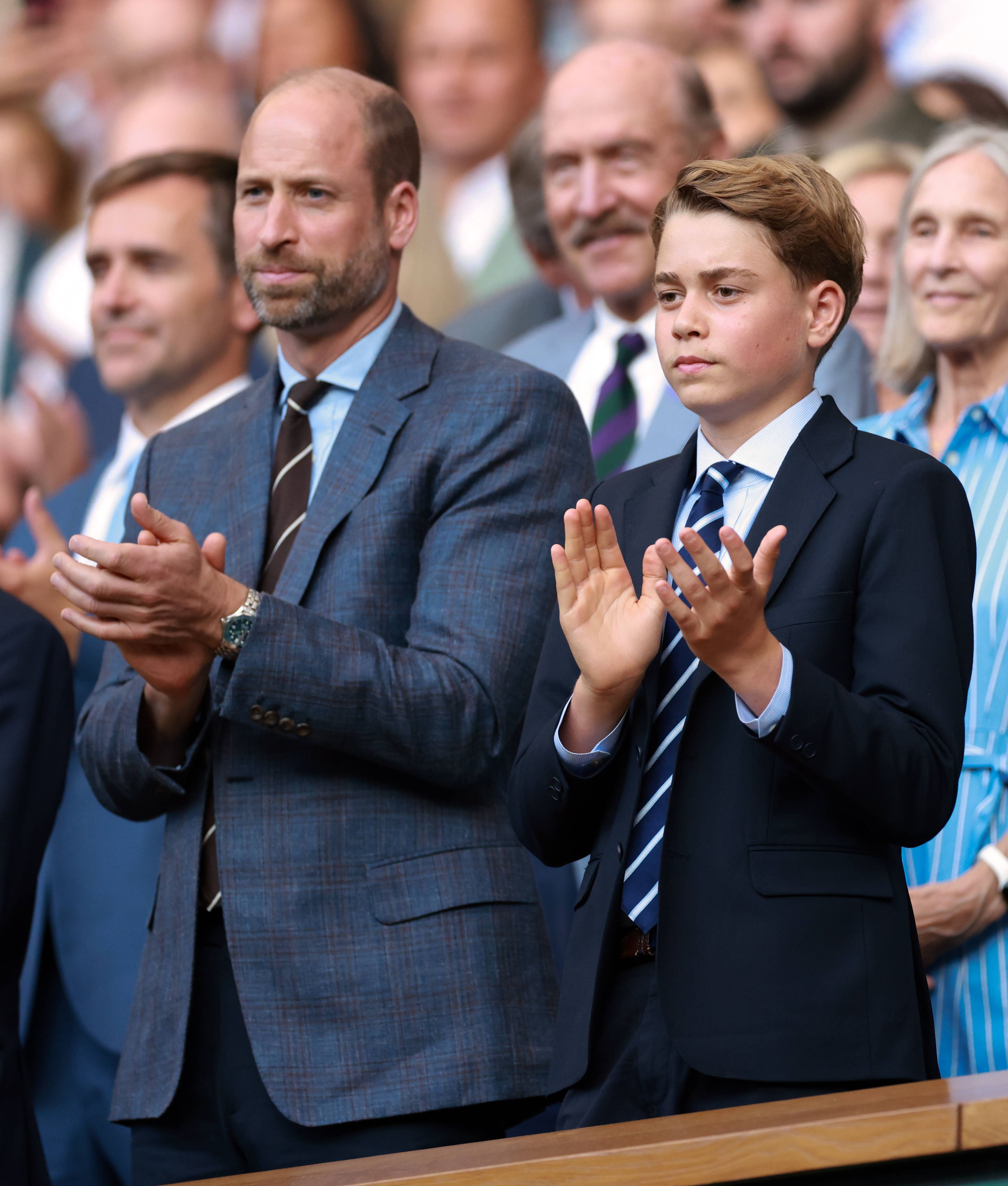Prinz William und Prinz George klatschen.