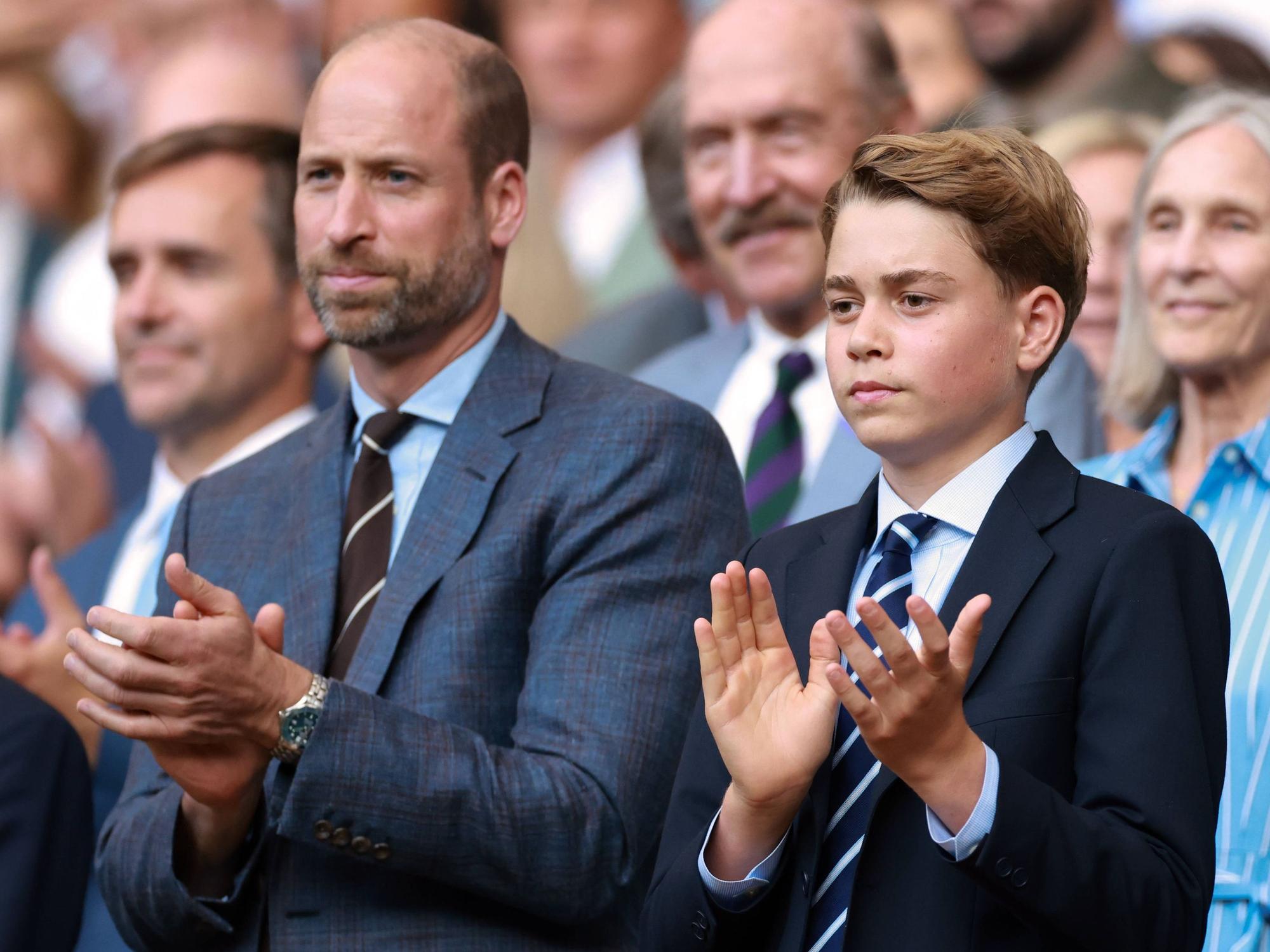 Prinz William und Prinz George klatschen.