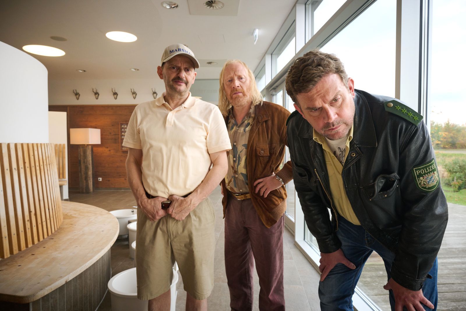 Golf-Marshall Marek Bufka (Milan Peschel, links), Rudi Birkenberger (Simon Schwarz) und Franz Eberhofer (Sebastian Bezzel, rechts) begutachten den Leichenfund im Wellnessbereich.  (Bild: Constantin Film Distribution GmbH / Bernd Schuller)