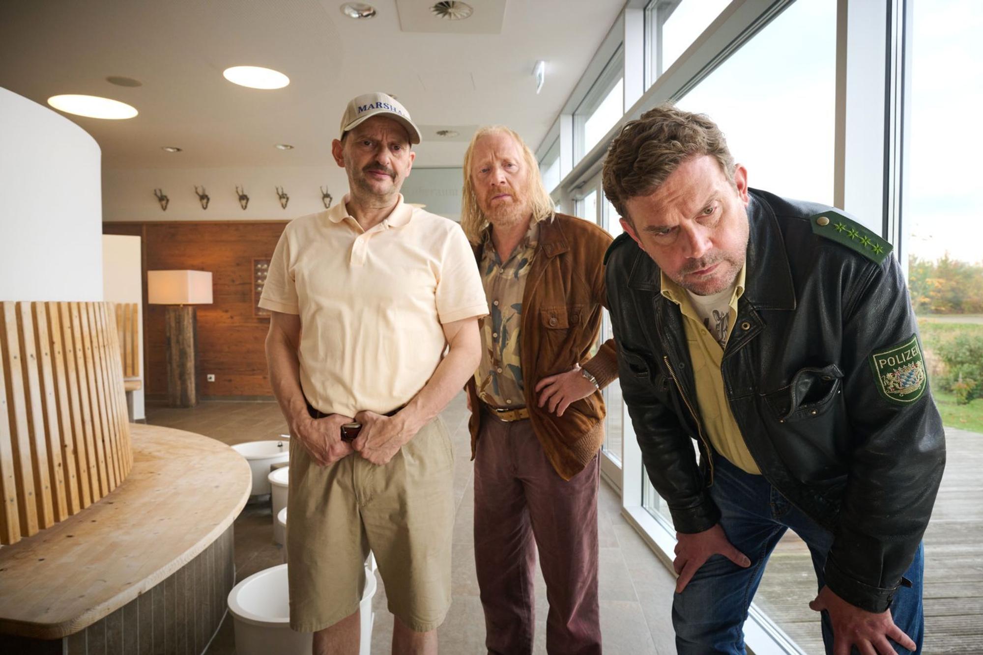 Golf-Marshall Marek Bufka (Milan Peschel, links), Rudi Birkenberger (Simon Schwarz) und Franz Eberhofer (Sebastian Bezzel, rechts) begutachten den Leichenfund im Wellnessbereich. (Bild: Constantin Film Distribution GmbH / Bernd Schuller)