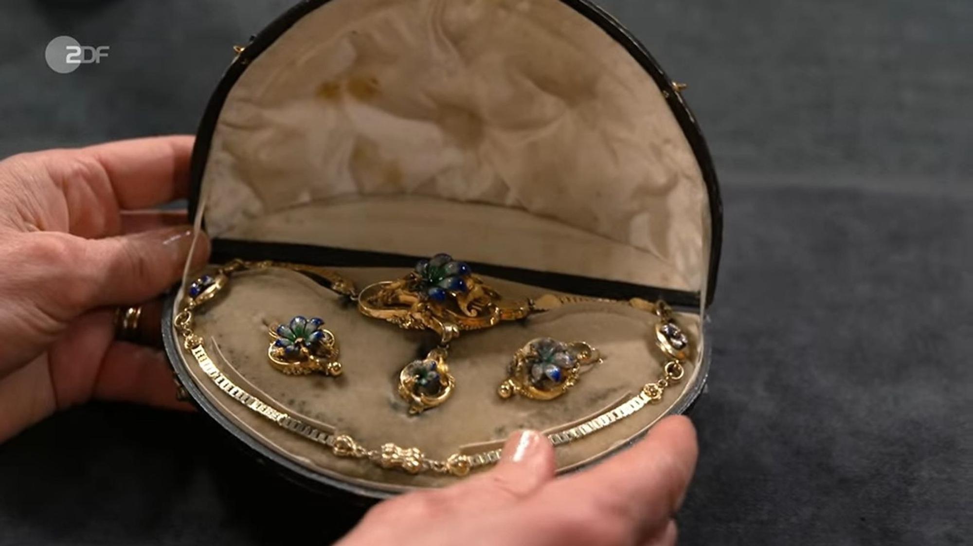 Ein florales Schmuckset im historischen Etui machte nicht nur bei der Expertin Eindruck. Goldkette und Ohrhänger mit Emaille stammten aus der Zeit zwischen 1845 und 1860. Die Expertise lag bei 2.800 bis 3.000 Euro - schon allein der Goldwert wurde auf 2.400 Euro beziffert. (Bild: ZDF)