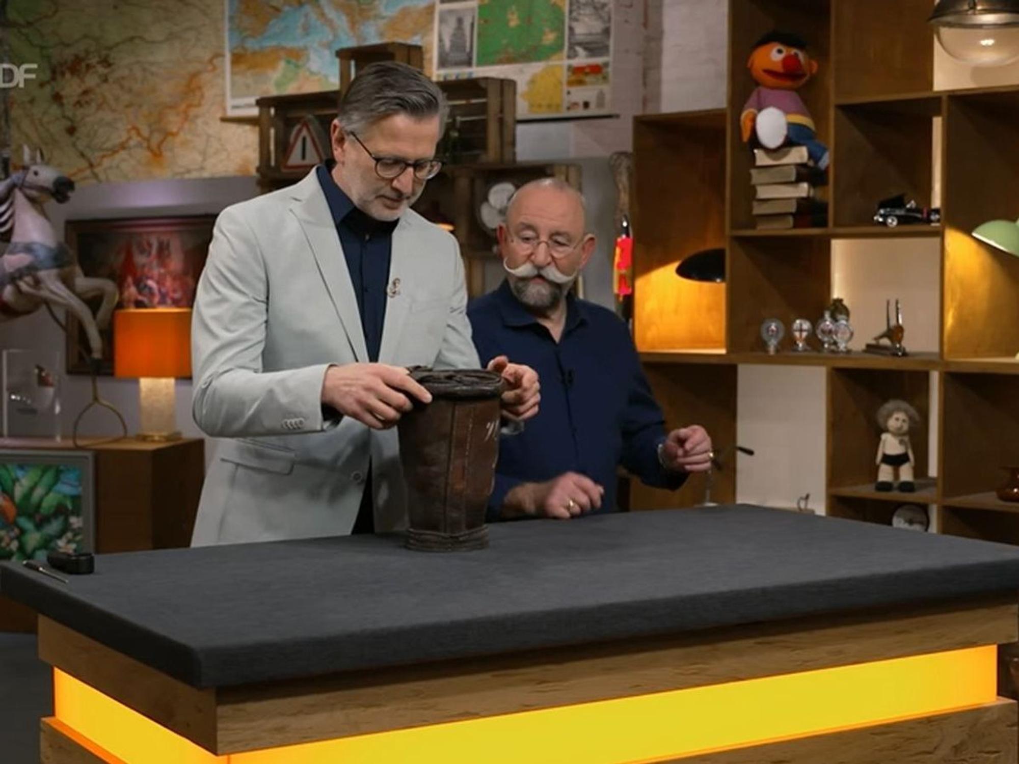 „Was haben wir denn jetzt?“, fragte sich Horst Lichter in der neusten Folge von „Bares für Rares“. „Vom Harry Potter das Hütchen?“ Mit dieser Vermutung lag der Gastgeber allerdings ziemlich weit daneben. „Sowas in der Art“, lachte Detlev Kümmel. „Eine Vase ist es schon mal nicht.“ (Bild: ZDF)