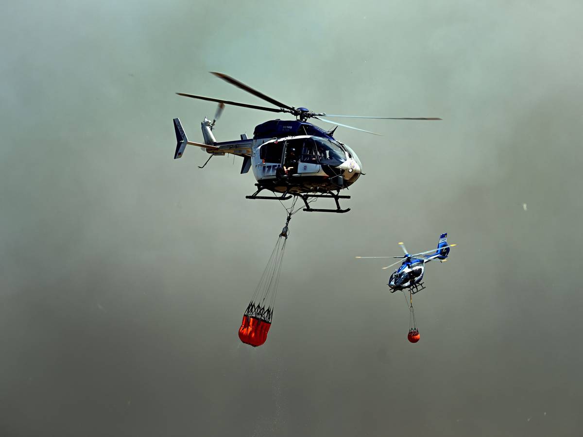 Helikopter fliegen an, um Wasser in Löschwasser-Außenlastbehältern zum Einsatz beim Waldbrand im Hürtgenwald aufzunehmen.
