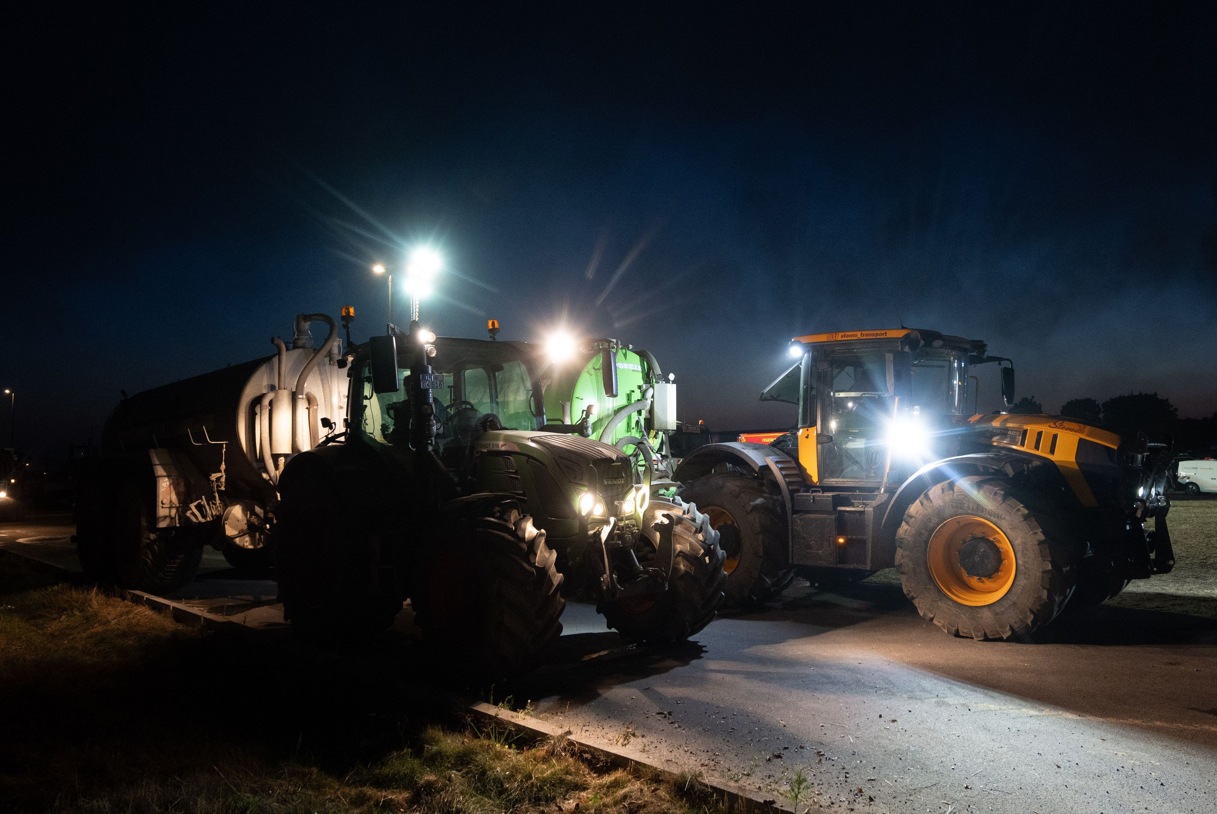 Fahrer von Traktoren warten in Hürtgenwald-Kleinhau auf die Befüllung ihrer Fässer mit Wasser, um damit die Feuerwehr beim Löschen des Waldbrands im Hürtgenwalds zu unterstützen.