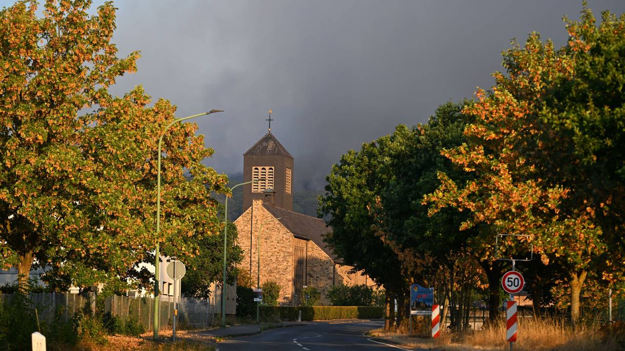 Dichter Rauch eines Waldbrands im Hürtgenwald steigt hinter der Kirche des Ortsteils Gey auf.