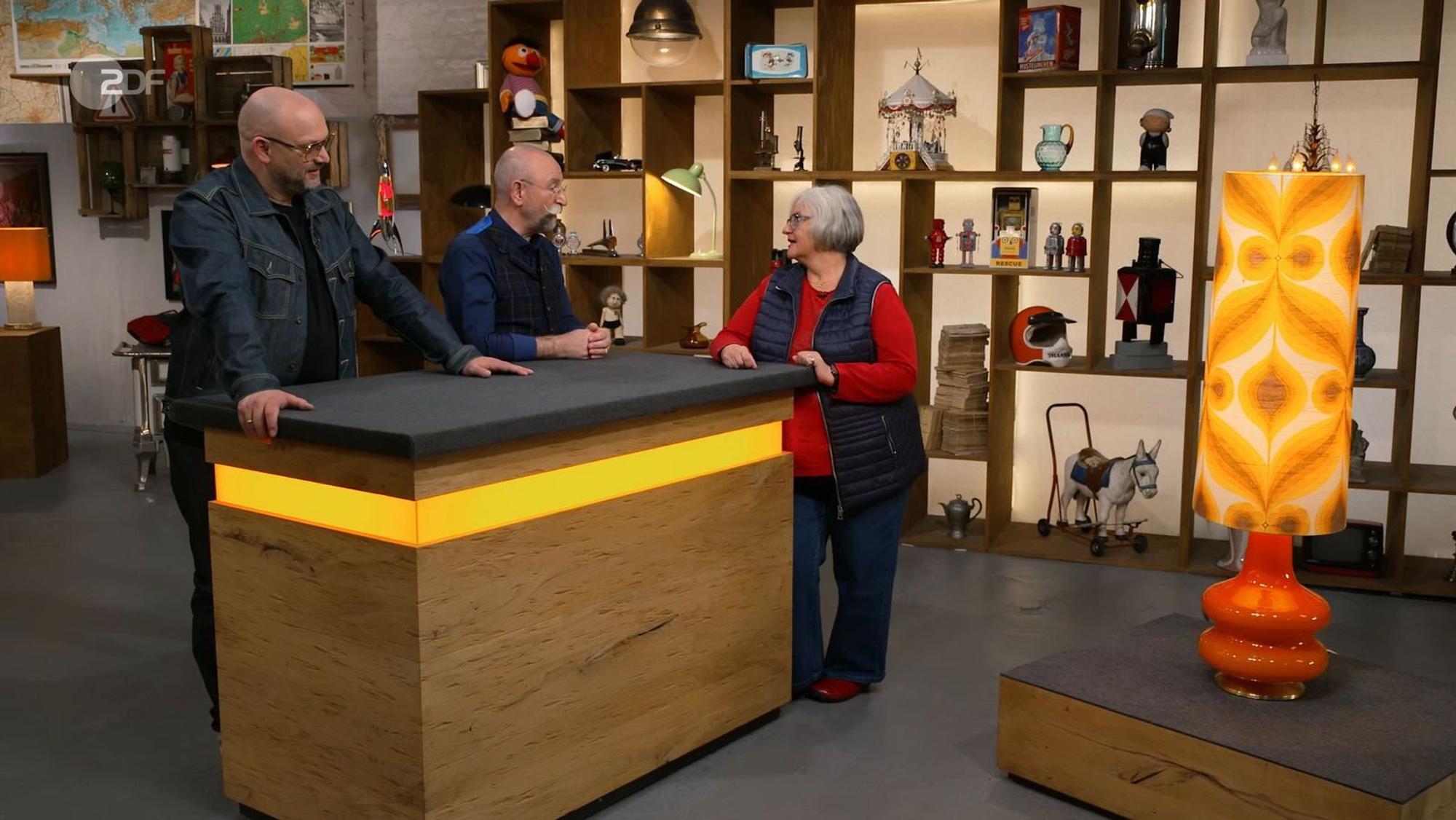 „Die 70er leben wieder!“, jubelte „Bares für Rares“-Moderator Horst Lichter (Mitte), als er die Leuchte erblickte.
(Bild: ZDF)