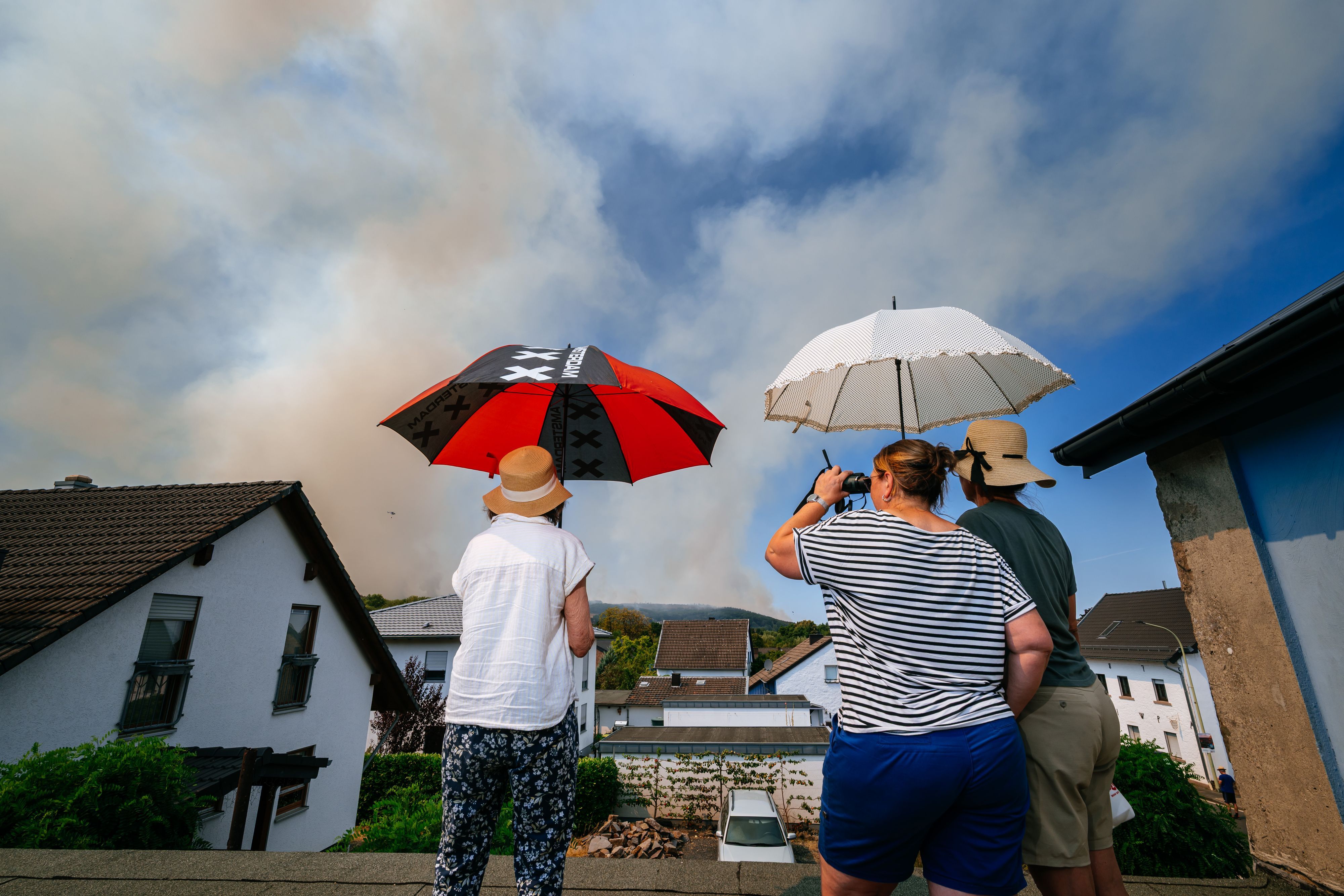 Einwohner des Ortsteils Straß beobachten die Entwicklung des Brandes aus der Ferne.