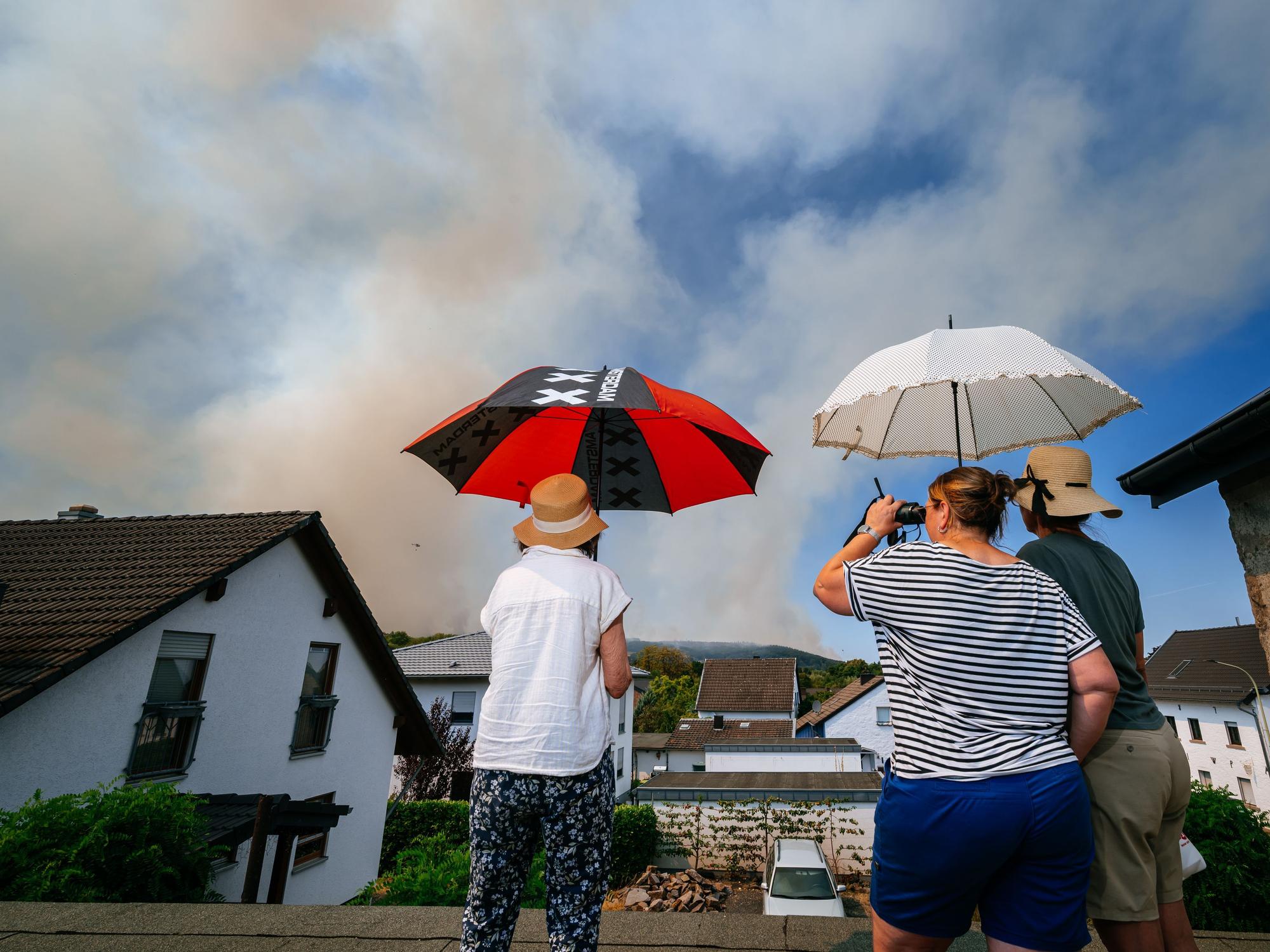 Einwohner des Ortsteils Straß beobachten die Entwicklung des Brandes aus der Ferne.