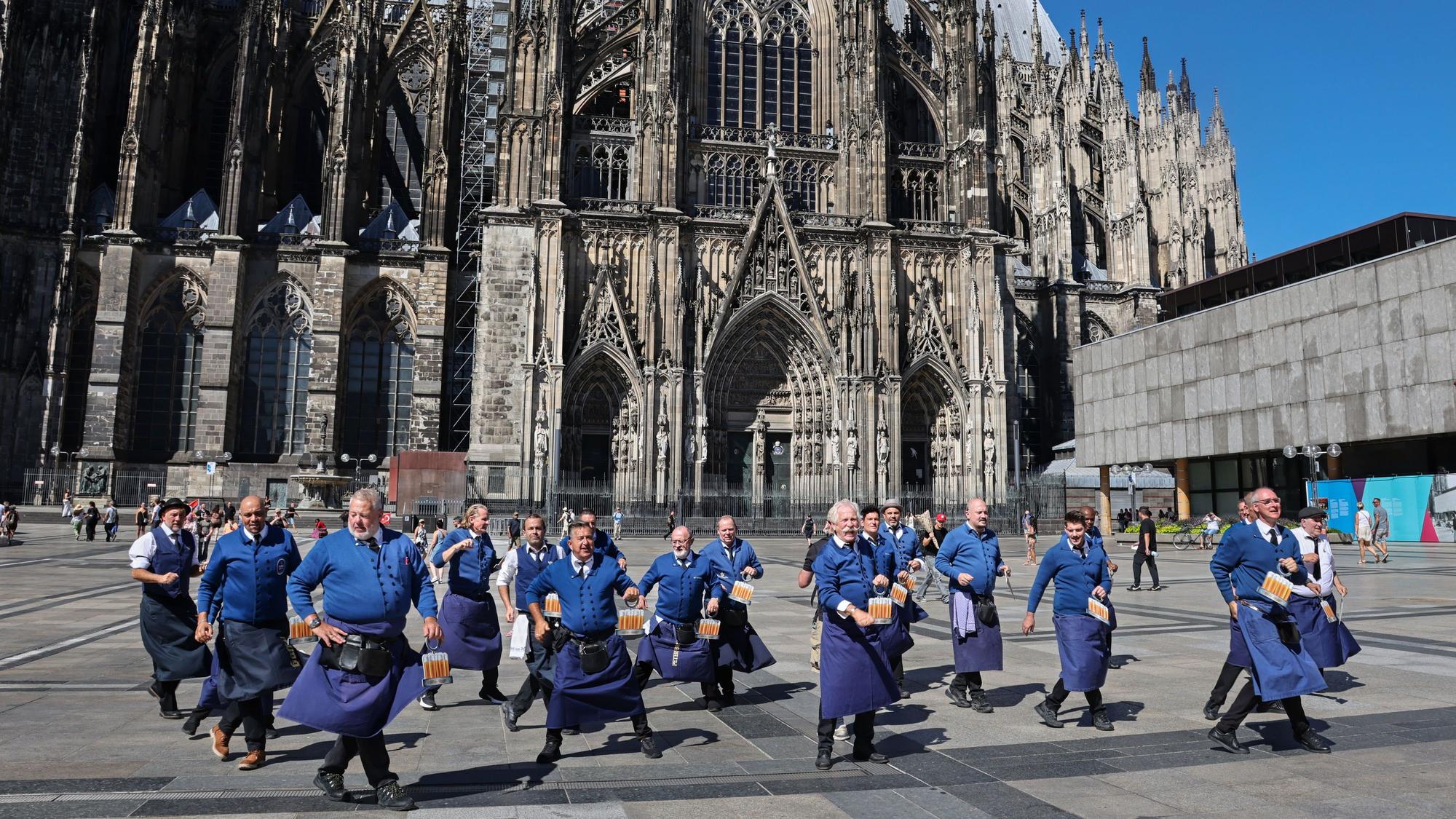 Die Köbesse tanzen mit Henning Krautmacher auf dem Roncalliplatz.