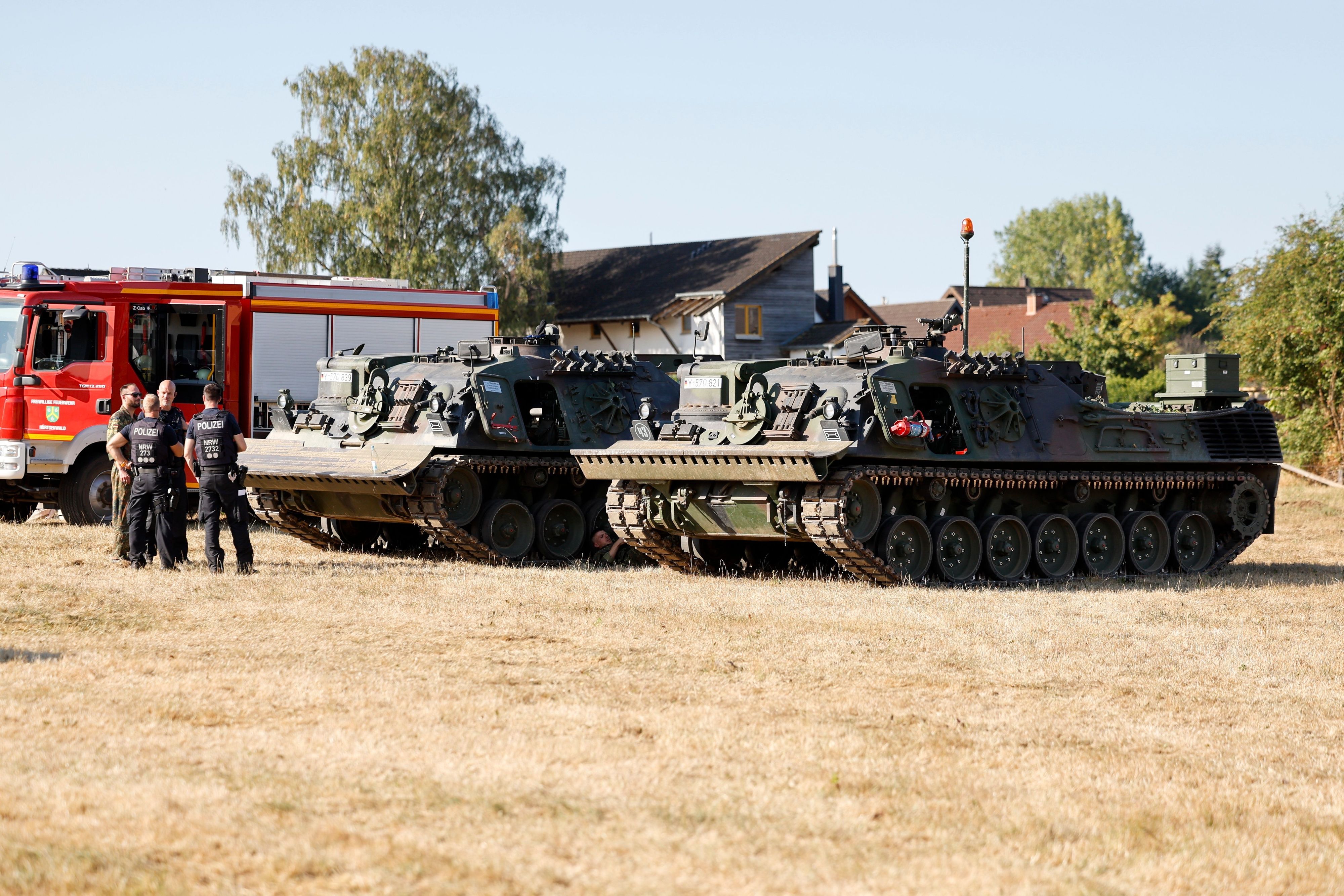 Zwei Räumungspanzer der Bundeswehr stehen auf einer Wiese.