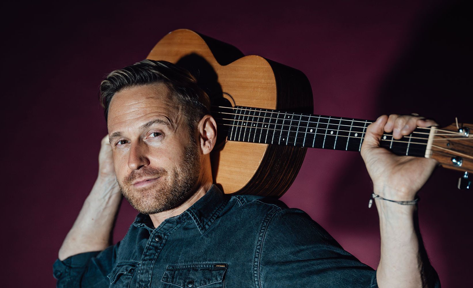 Philipp Godart posiert mit seiner Gitarre.
