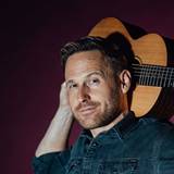 Philipp Godart posiert mit seiner Gitarre.