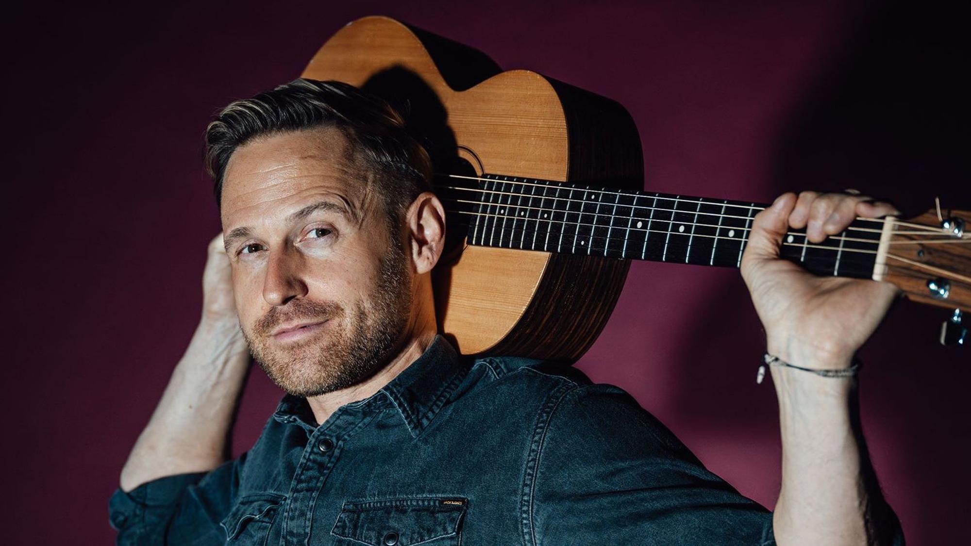 Philipp Godart posiert mit seiner Gitarre.