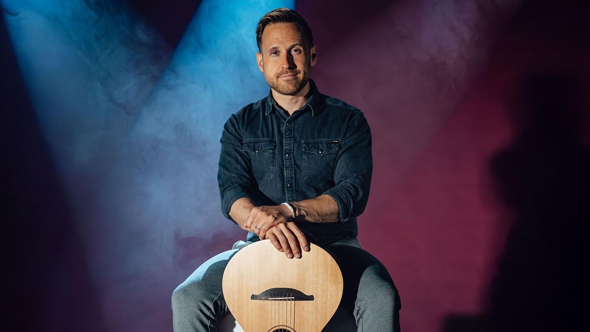 Philipp Godart posiert mit seiner Gitarre.