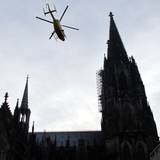 Ein ADAC-Rettungshubschrauber fliegt über den Dom in Köln hinweg. (Archivbild)