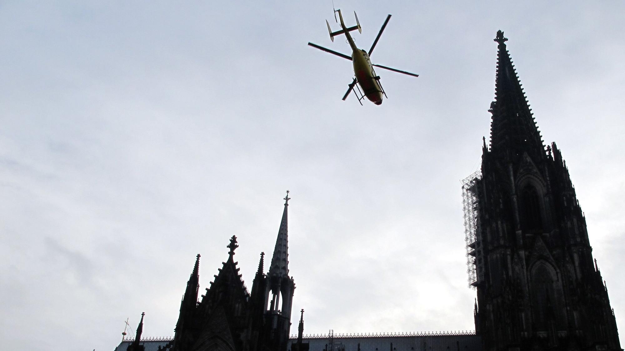 Ein ADAC-Rettungshubschrauber fliegt über den Dom in Köln hinweg. (Archivbild)