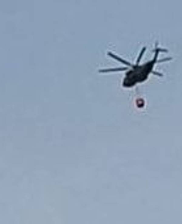 Ein Hubschrauber fliegt am Samstagmorgen Richtung Hürtgenwald zum Löscheinsatz und überquert dabei Köln-Bocklemünd.