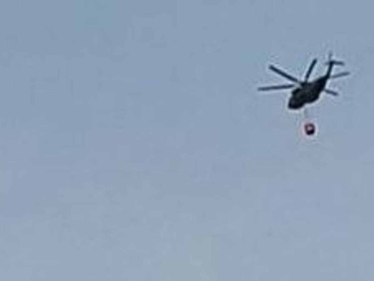 Ein Hubschrauber fliegt am Samstagmorgen Richtung Hürtgenwald zum Löscheinsatz und überquert dabei Köln-Bocklemünd.