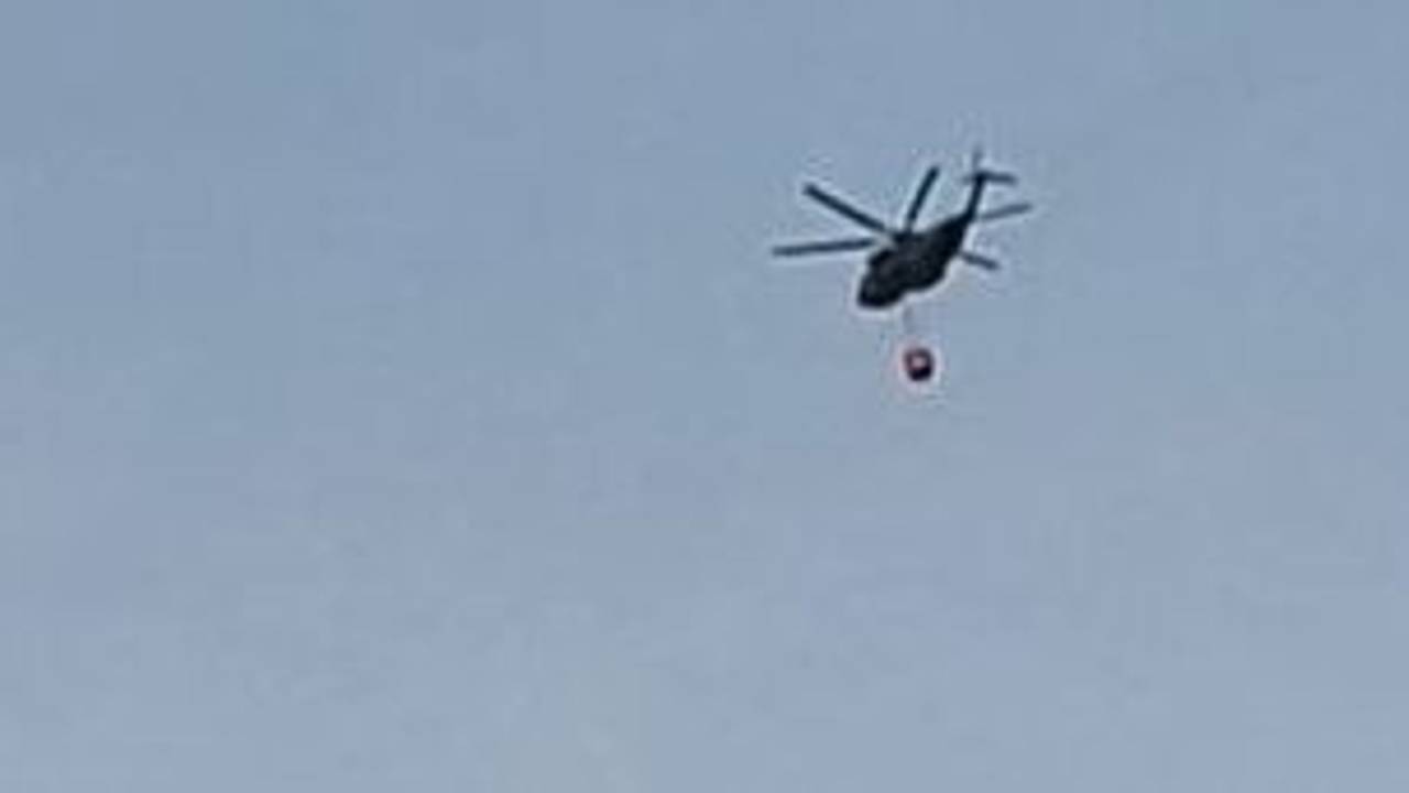 Ein Hubschrauber fliegt am Samstagmorgen Richtung Hürtgenwald zum Löscheinsatz und überquert dabei Köln-Bocklemünd.