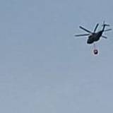 Ein Hubschrauber fliegt am Samstagmorgen Richtung Hürtgenwald zum Löscheinsatz und überquert dabei Köln-Bocklemünd.