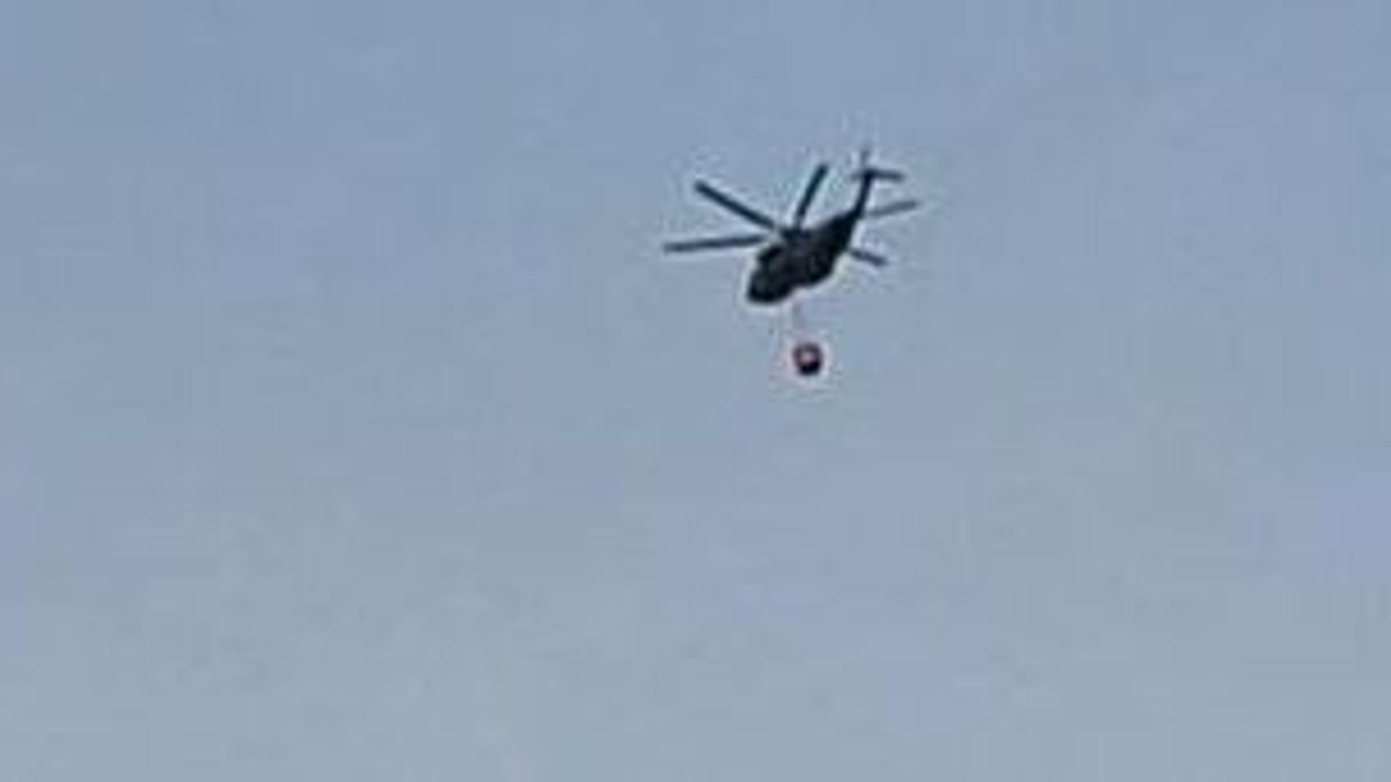 Ein Hubschrauber fliegt am Samstagmorgen Richtung Hürtgenwald zum Löscheinsatz und überquert dabei Köln-Bocklemünd.