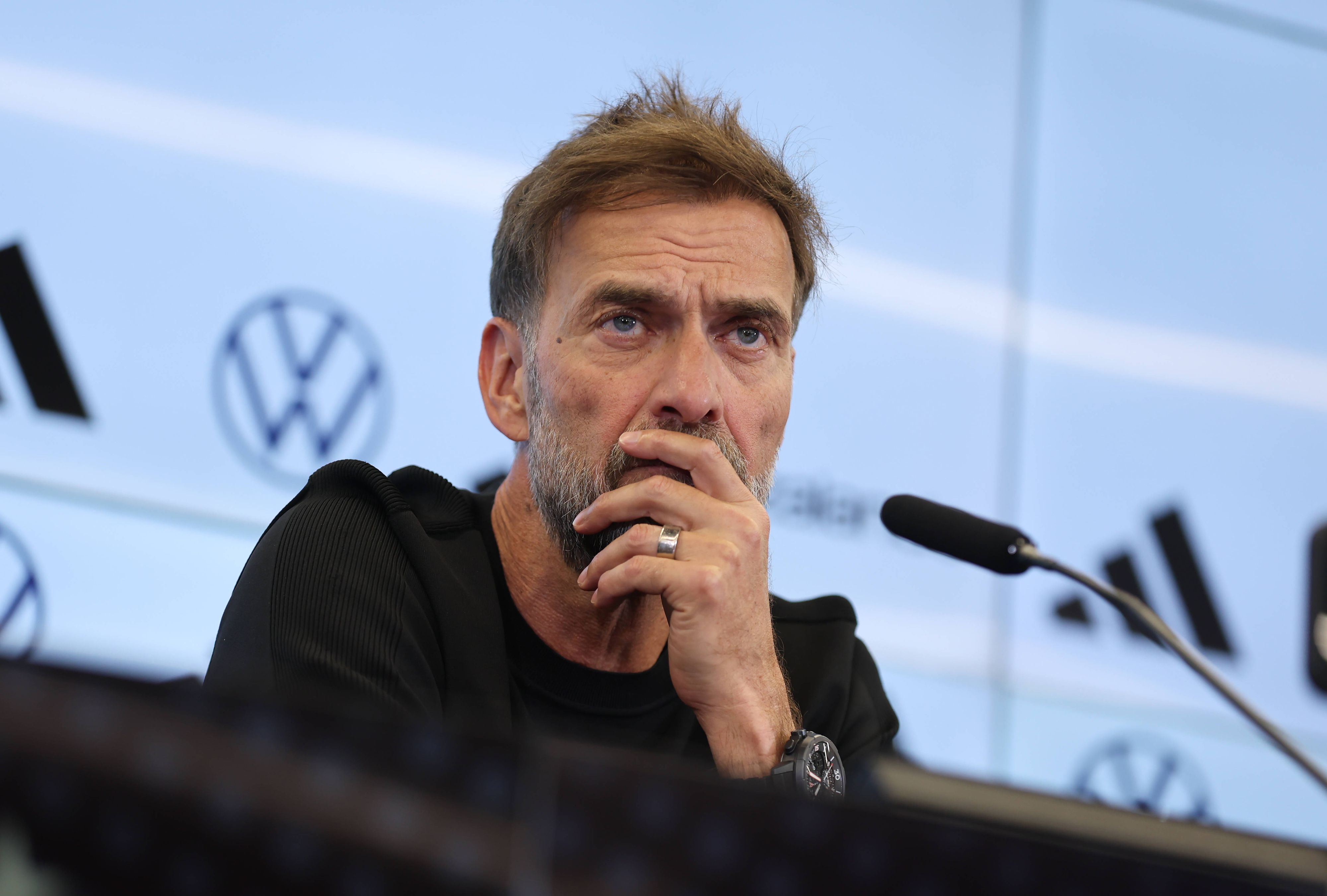 Jürgen Klopp hört bei einer Pressekonferenz einem Journalisten zu.