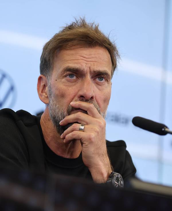 Jürgen Klopp hört bei einer Pressekonferenz einem Journalisten zu.
