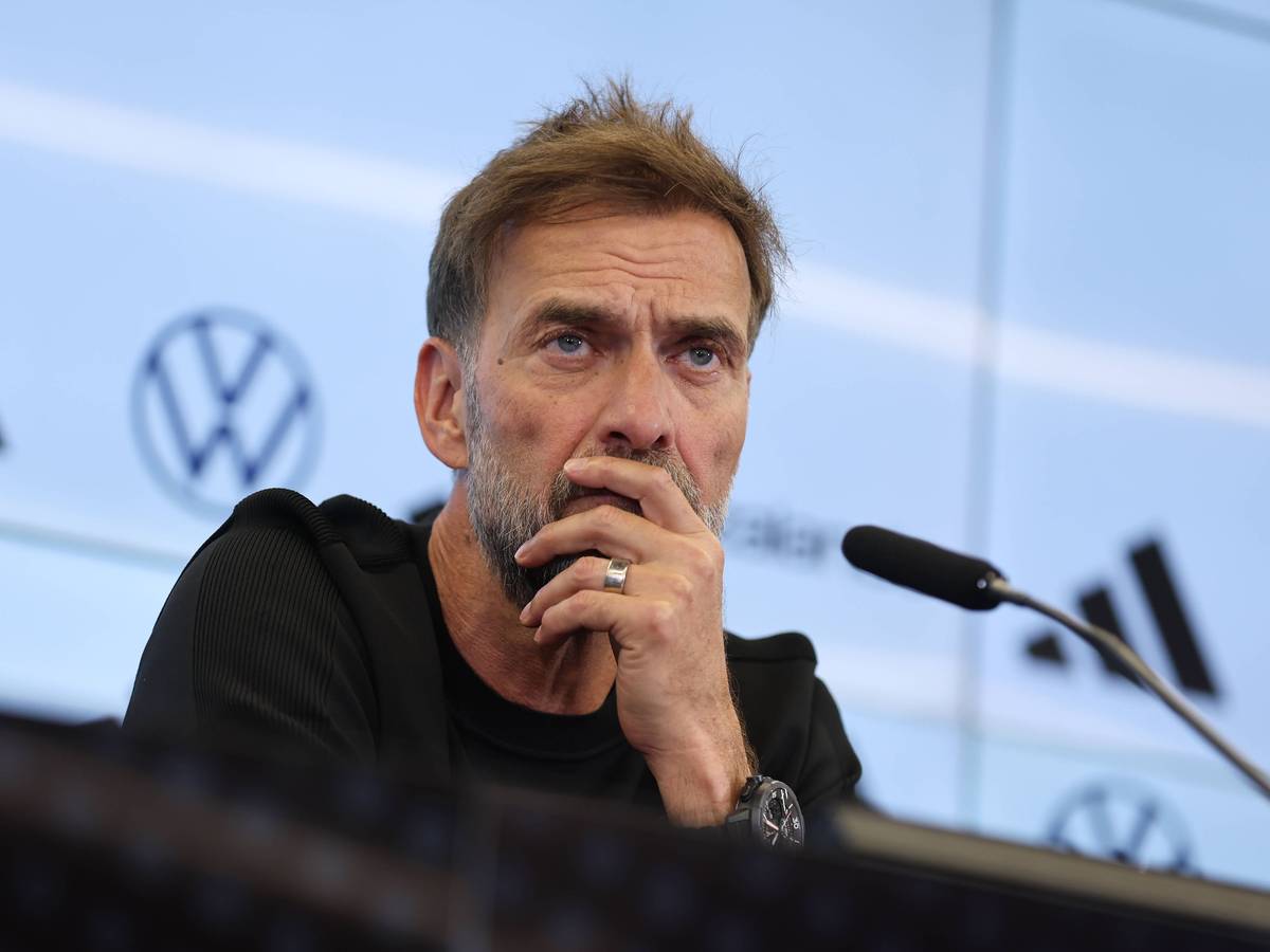 Jürgen Klopp hört bei einer Pressekonferenz einem Journalisten zu.