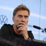 Jürgen Klopp hört bei einer Pressekonferenz einem Journalisten zu.
