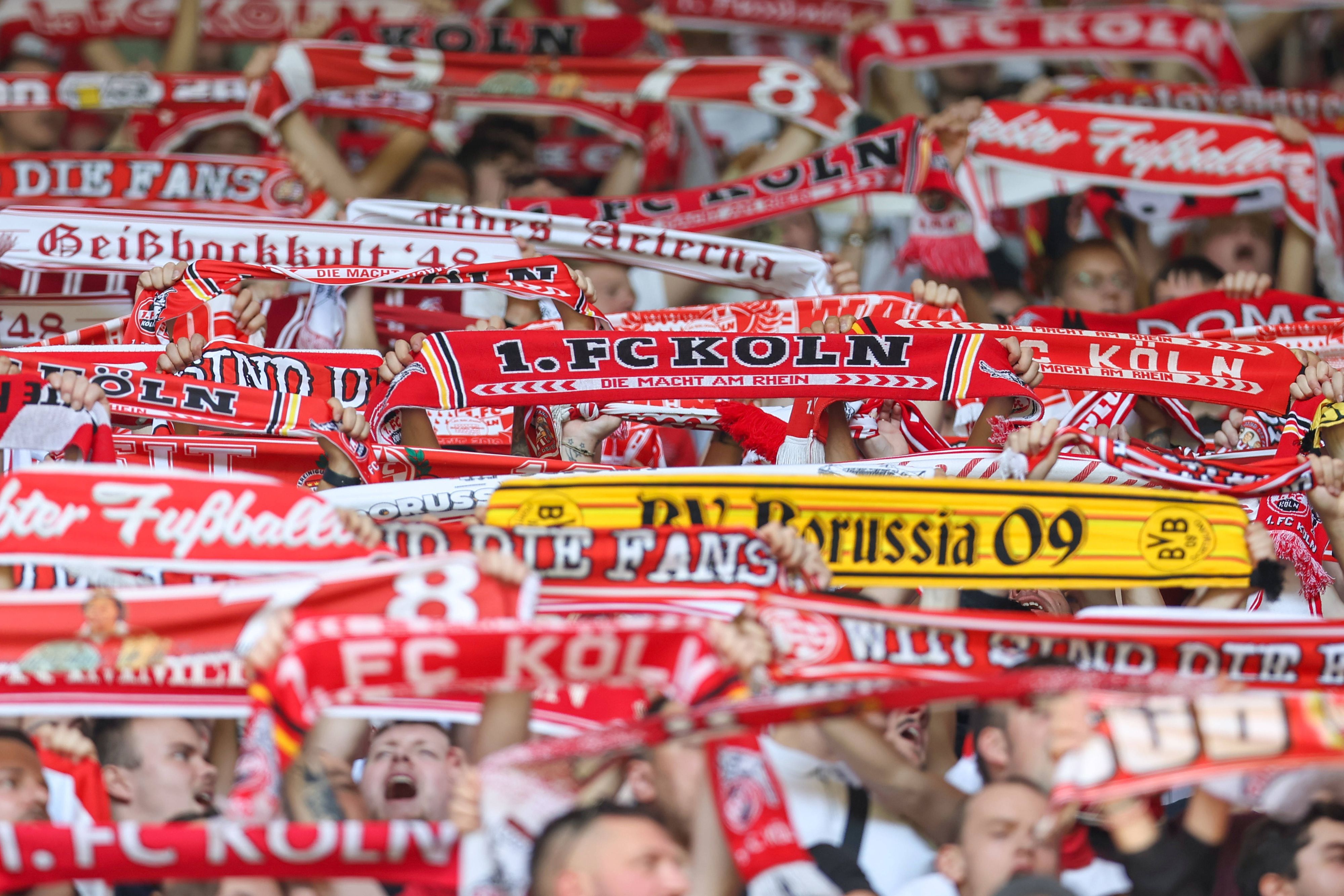 Zwischen Fanschals des 1. FC Köln ist auch ein Schal von Borussia Dortmund zu sehen.