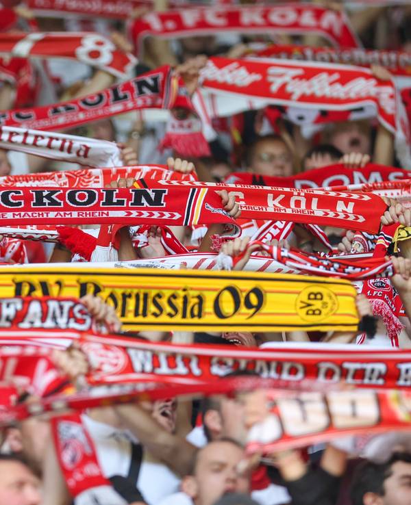 Zwischen Fanschals des 1. FC Köln ist auch ein Schal von Borussia Dortmund zu sehen.