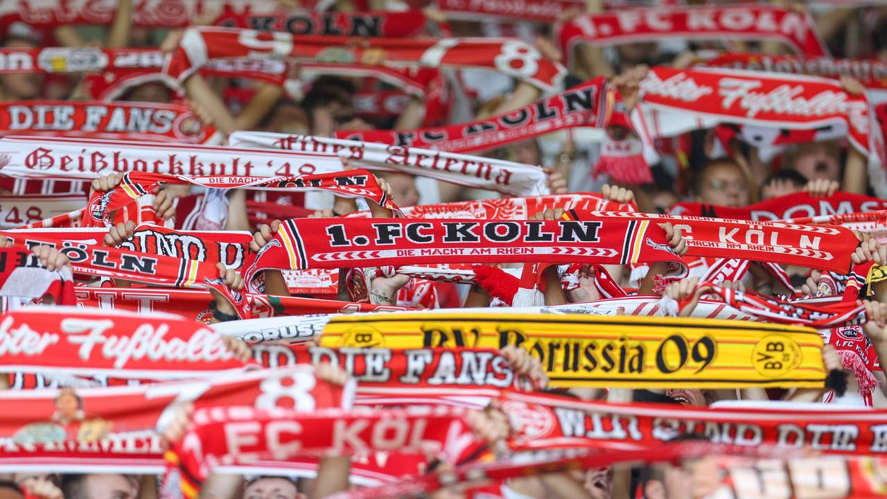 Zwischen Fanschals des 1. FC Köln ist auch ein Schal von Borussia Dortmund zu sehen.