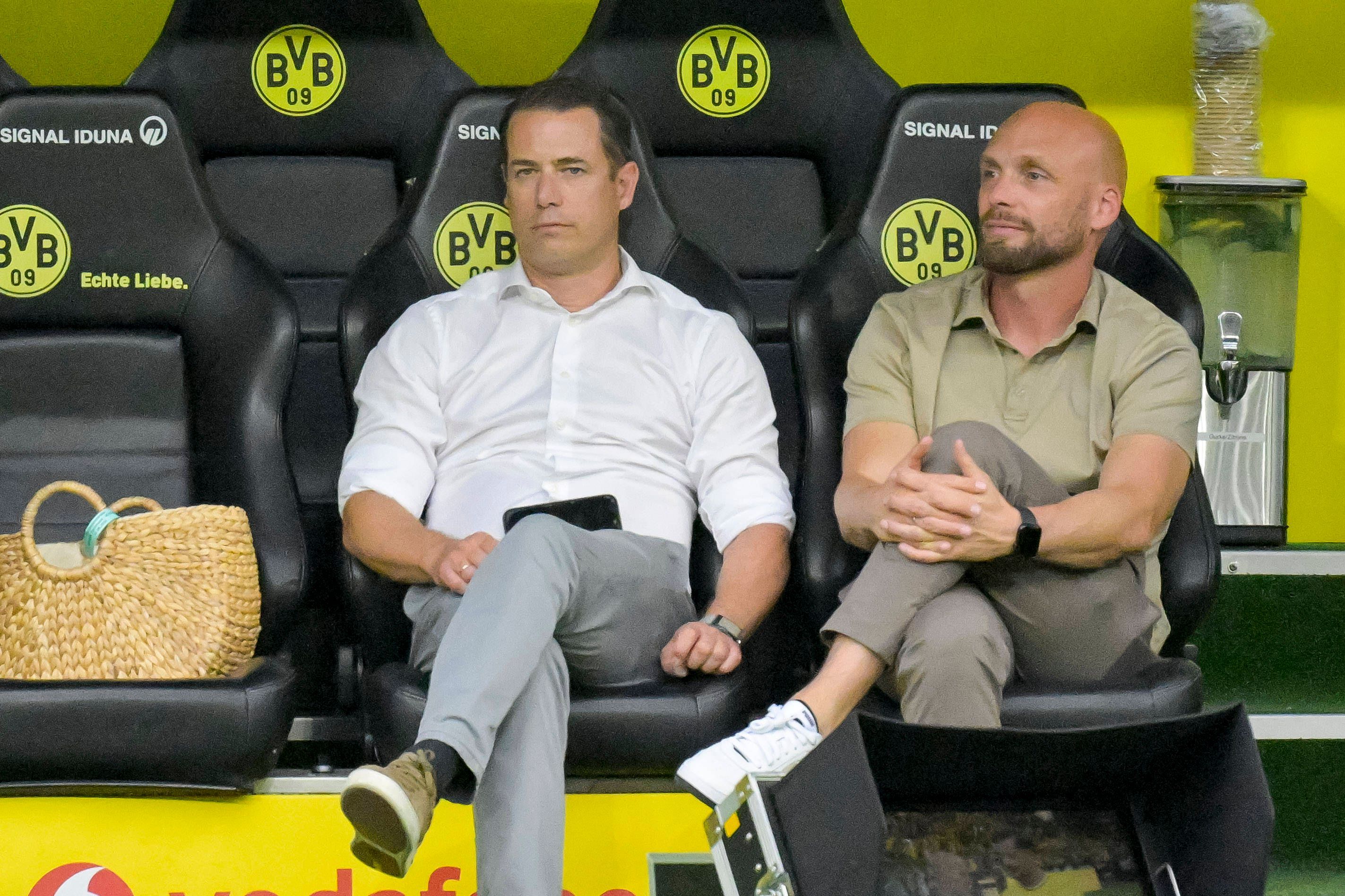 Lars Ricken und Ole Book sitzen auf der BVB-Ersatzbank.