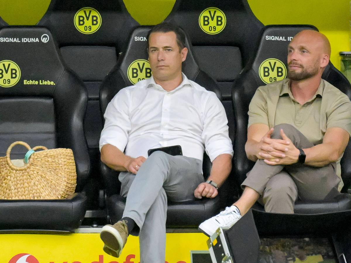 Lars Ricken und Ole Book sitzen auf der BVB-Ersatzbank.