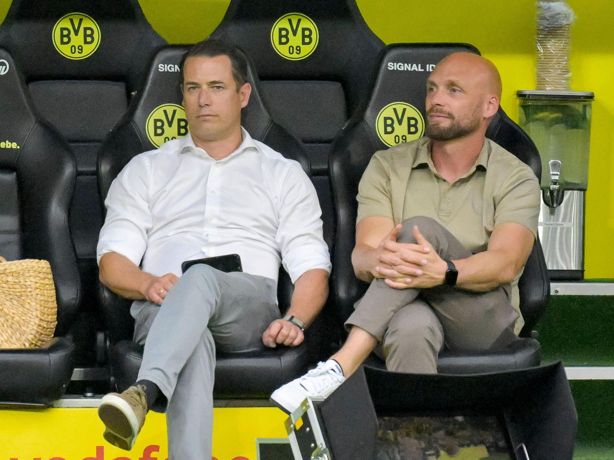 Lars Ricken und Ole Book sitzen auf der BVB-Ersatzbank.