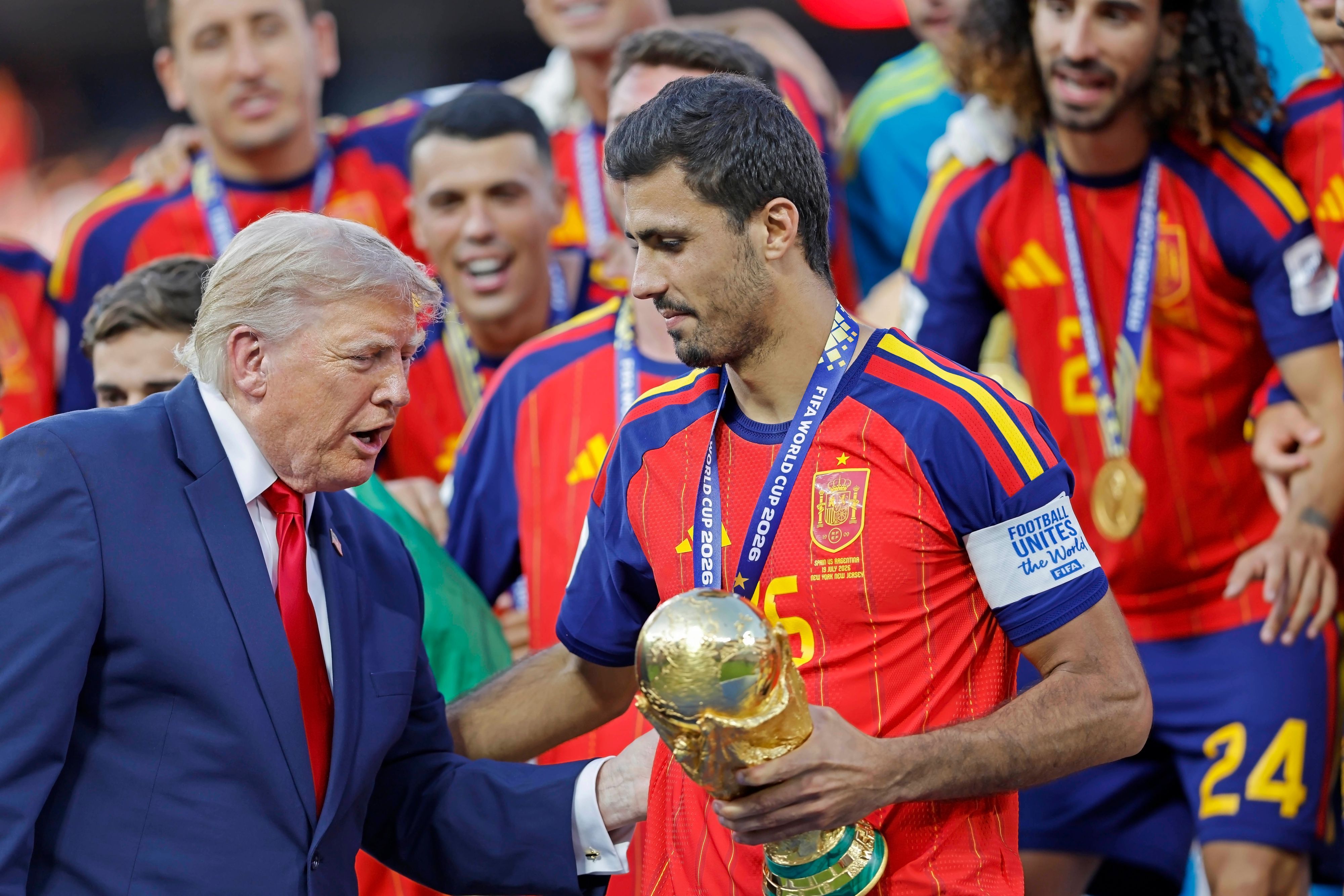 Donald Trump überreicht Rodri den WM-Pokal.