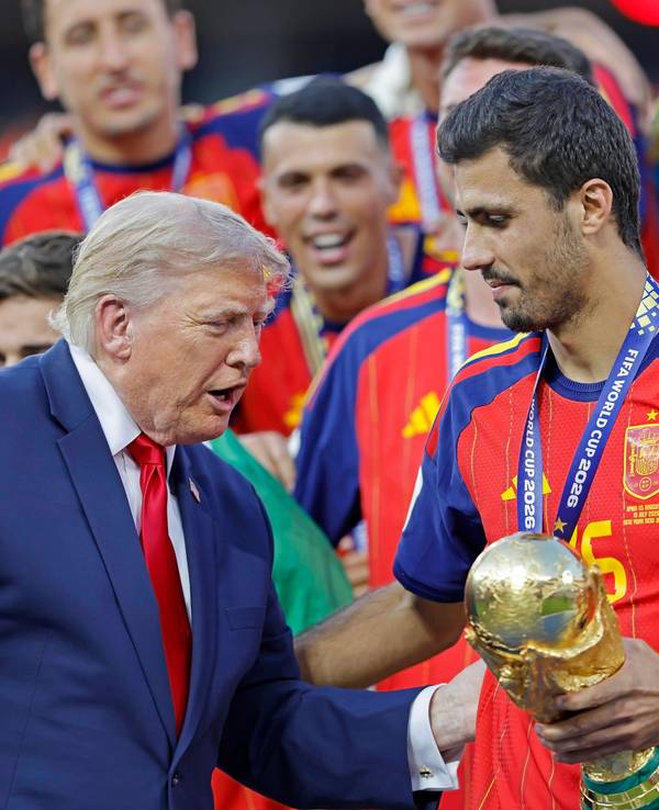 Donald Trump überreicht Rodri den WM-Pokal.