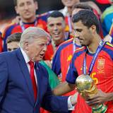 Donald Trump überreicht Rodri den WM-Pokal.