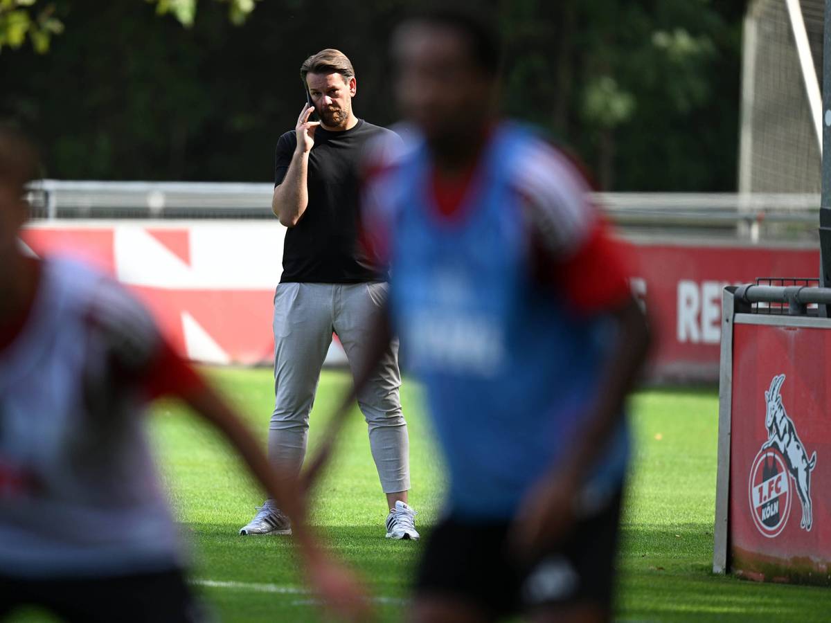 Thomas Kessler telefoniert, während er das FC-Training beobachtet.