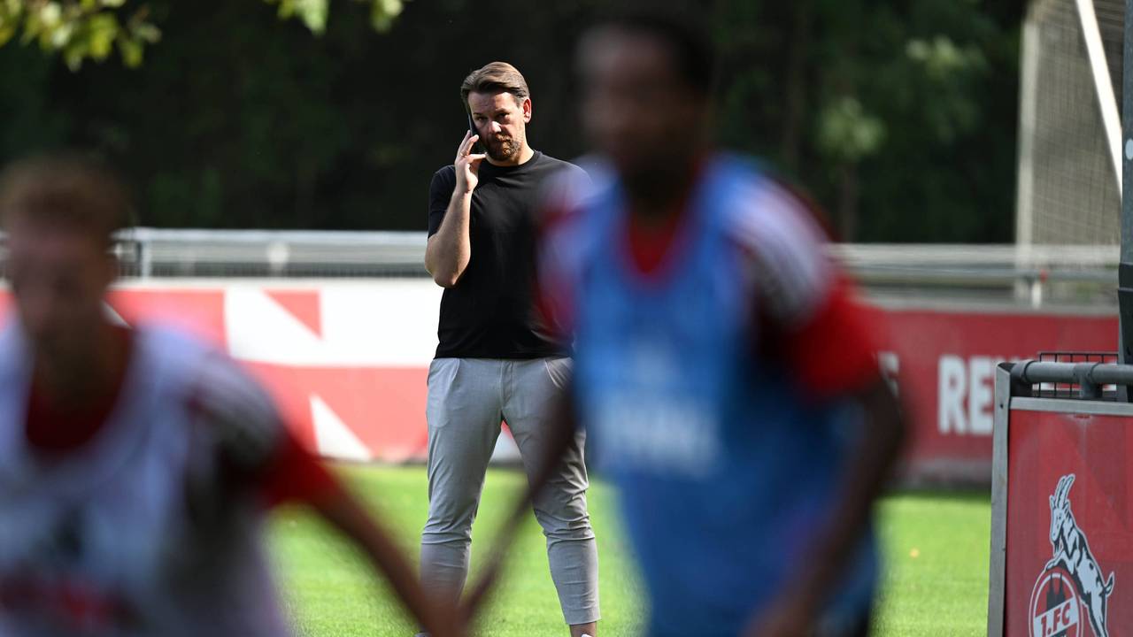 Thomas Kessler telefoniert, während er das FC-Training beobachtet.