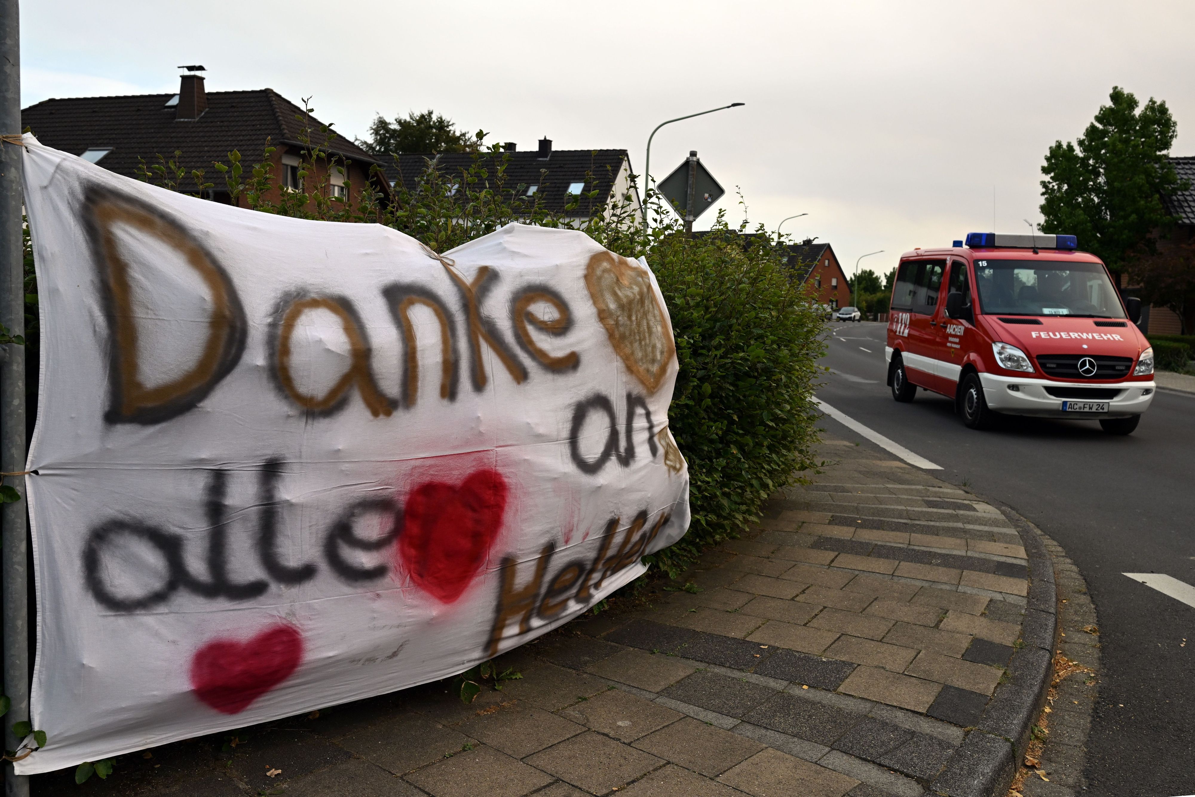 Ein Feuerwehrauto fährt an einem Banner mit der Aufschrift „Danke an alle Helfer“ vorbei. Den Waldbrand im Hürtgenwald haben die Einsatzkräfte unter Kontrolle gebracht.