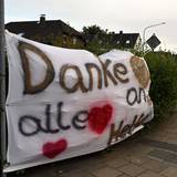 Ein Feuerwehrauto fährt an einem Banner mit der Aufschrift „Danke an alle Helfer“ vorbei. Den Waldbrand im Hürtgenwald haben die Einsatzkräfte unter Kontrolle gebracht.