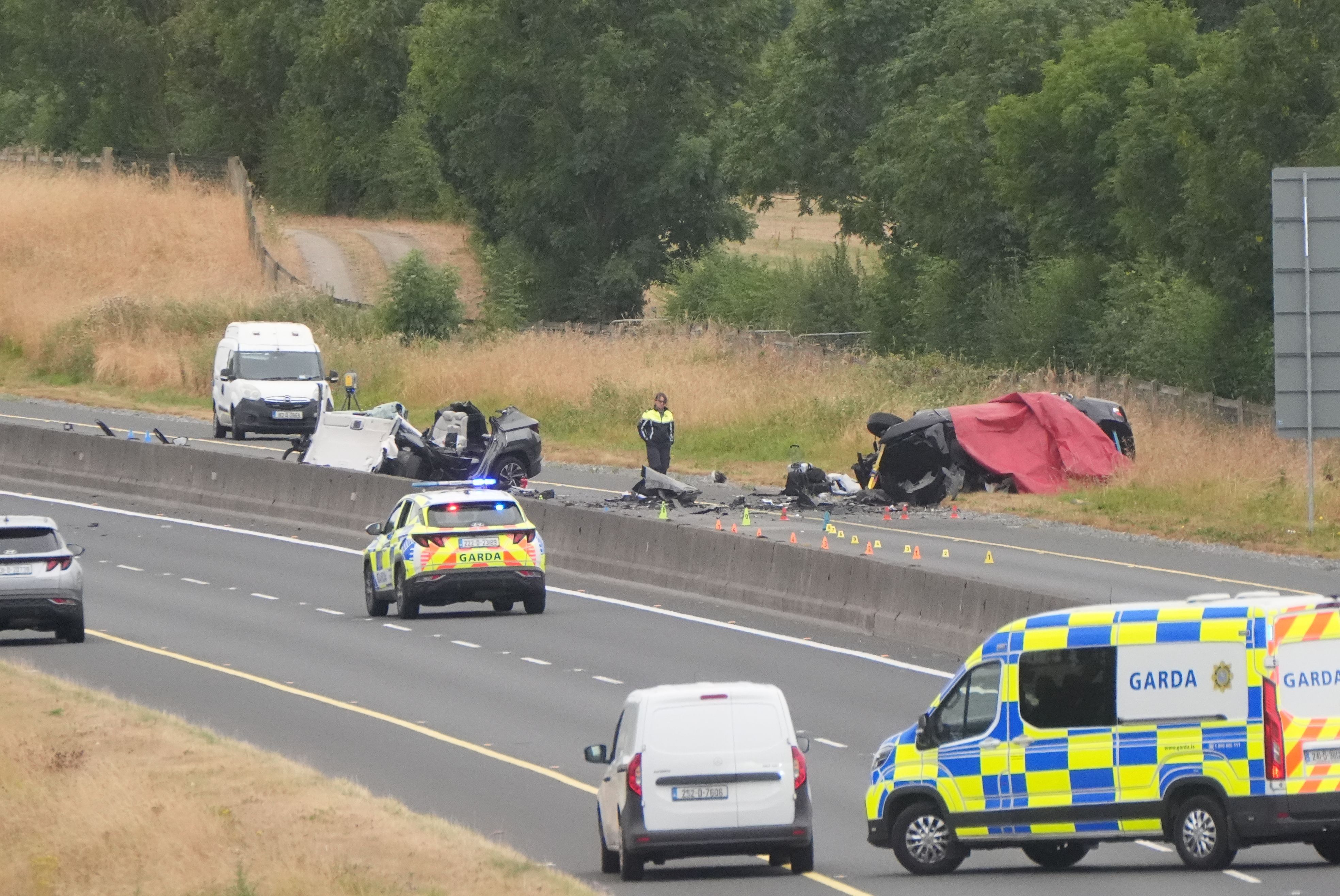 Einsatzkräfte stehen am Unfallort auf der M9 in Richtung Norden an der Anschlussstelle 3 im County Kildare. Bei einem Frontalzusammenstoß zwischen zwei PKWs sind mehrere Menschen ums Leben gekommen und weitere wurden schwer verletzt.