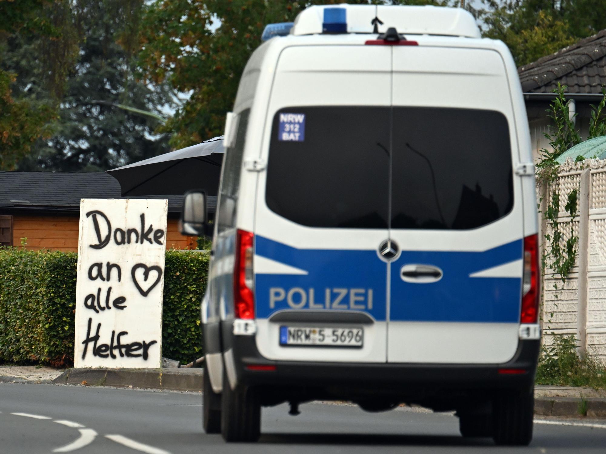 Ein Polizeifahrzeug fährt an einem Schild mit der Aufschrift „Danke an alle Helfer“ vorbei. unter Kontrolle gebracht. Foto: Federico Gambarini/dpa +++ dpa-Bildfunk +++