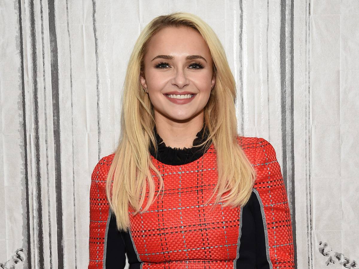Hayden Panettiere mit blonden Haaren und rotem Oberteil lächelt.