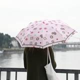 Eine Frau mit Regenschirm steht vor dem Rhein