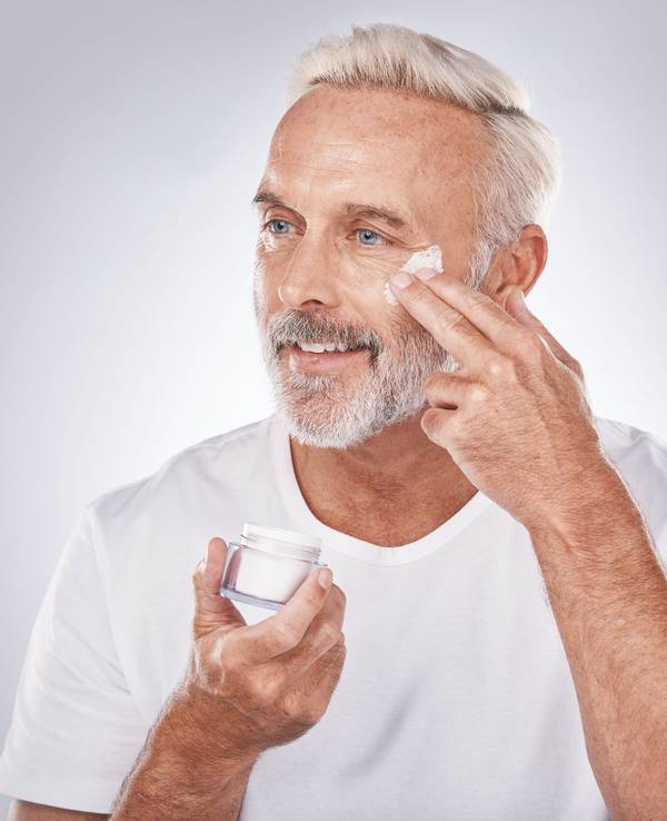 Ein Mann cremt sich das Gesicht ein